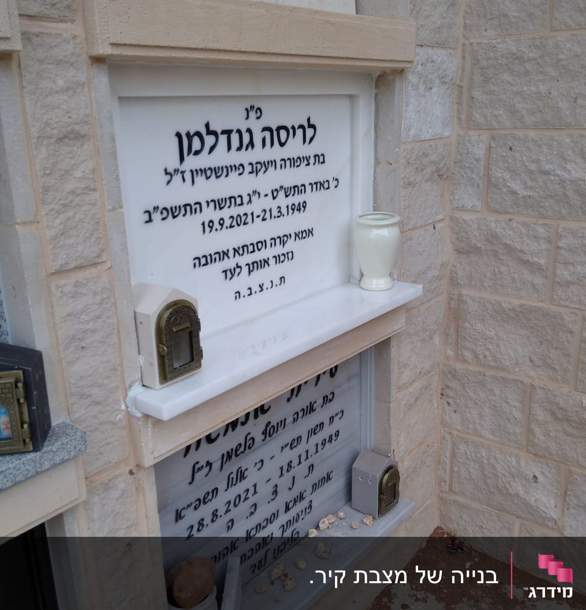 מצבות עם כיתוב בעברית, נרות ואבנים קטנות